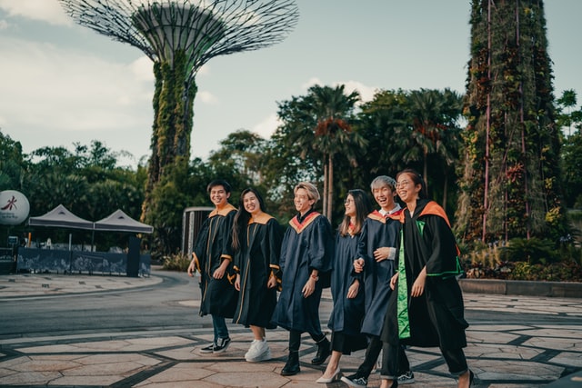 Graduates are walking together smiling